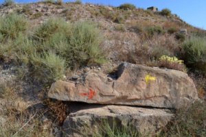 Rock with red arrow pointing right and yellow arrow pointing left.