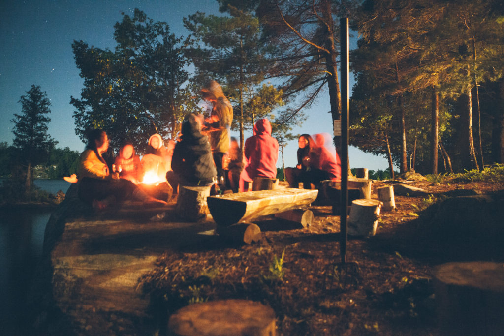 People gathered around a campfire at dusk